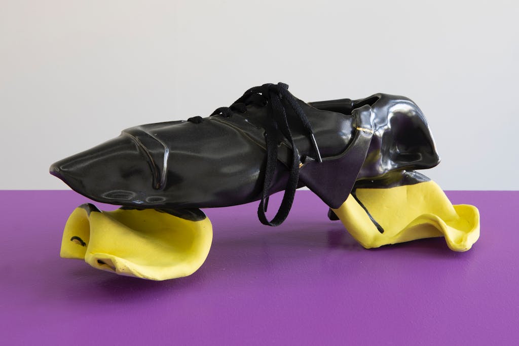 The Glissando Terraformers (2020)
 The first formal trainers designed to be worn on the surface of Mars. The black photoactive surface absorbs solar energy to harvest algae which is excreted through the yellow glissando soles allowing the wearer to glide on the planet’s surface. The algae in turn pumps out oxygen to thicken the planet’s atmosphere eventually making it habitable. Ceramic, gold paint, synthetic rubber, shoelace 
34 x 12 x 13 cm - © Photo: Robert Glas, Paris Internationale